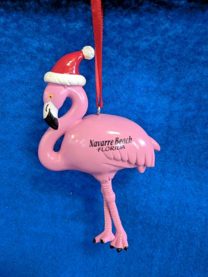Flamingo painted pink with a black and white bill. Santa Hat on the head. Navarre Beach Florida is painted across body and left wing.